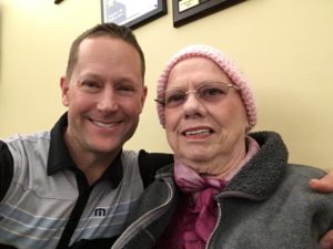 Author with arm around his mother at oncology office waiting room.